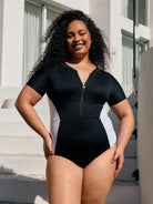 Model wearing an acapulco short sleeve one piece with zip through detail