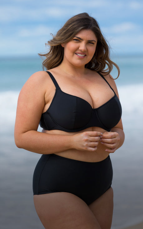 Model wearing supportive black underwire swim bra for big busts