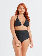 model wearing black ruched swim bottom with matching bikini top