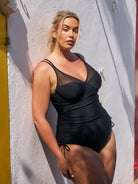 model wearing black side ruched one piece