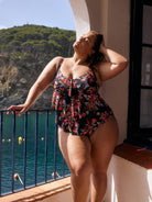 model wearing black and red floral three tier one piece