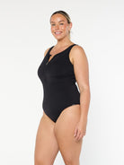 model showing side of black sleeveless zip up one piece
