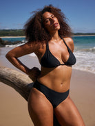 model wearing black triangle bikini at beach