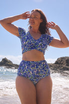 model wears blue floral bikini set at beach