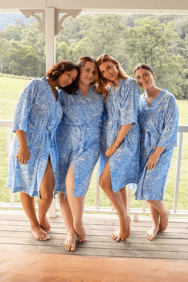 Group photo of models wearing blue paisley robes standing on deck