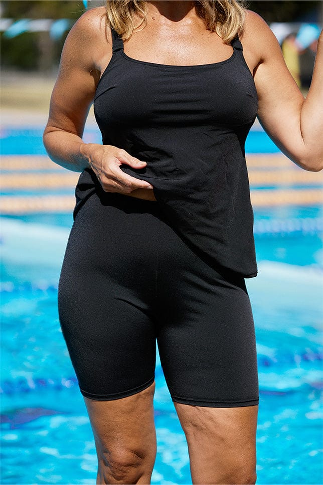 model wearing black bike swim pants with matching tankini