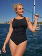 model on boat wearing black high neck one piece