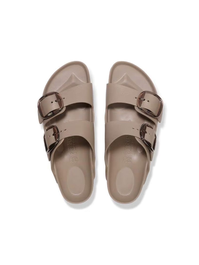 Pair of beige sandals with double buckles on a white background