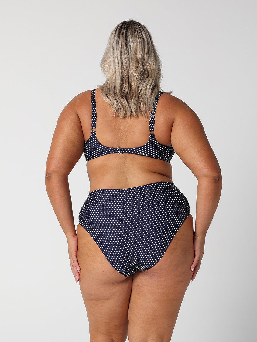 model showing cheeky cut of high rise navy dots bikini bottom