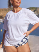 Blonde model wearing a loose white t shirt with graphics on back