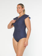 model showing side of navy polka dot frill sleeve one piece