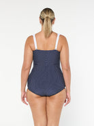 model showing back of navy and white dots retro inspired swimsuit