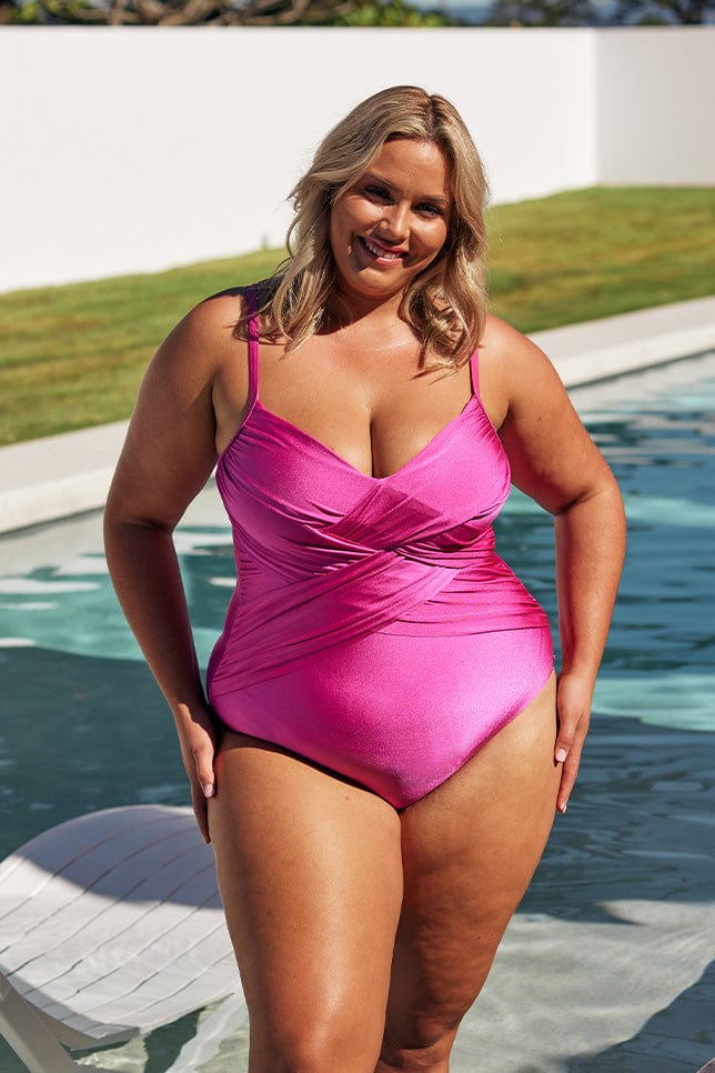 Blonde model wears hot pink criss cross womens one piece at pool