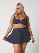 model wearing navy polka dot skater skirt with matching top