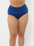 Model in studio wearing high waisted swim pant with full coverage