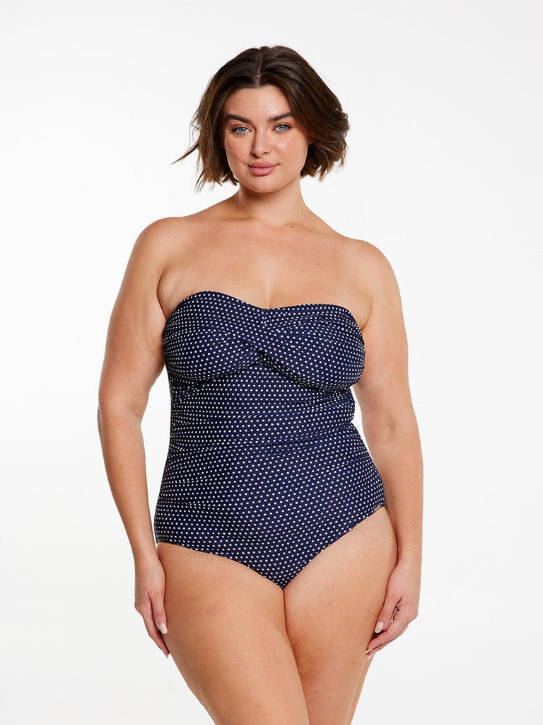 model wearing navy and white dots twist front bandeau swimsuit