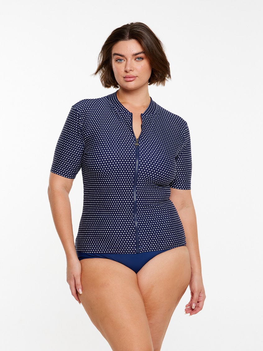 model wearing navy polka dot short sleeve rash vest