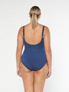 model showing scooped back on navy and white dots one piece