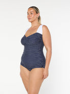 model showing side of navy polka dot retro style one piece