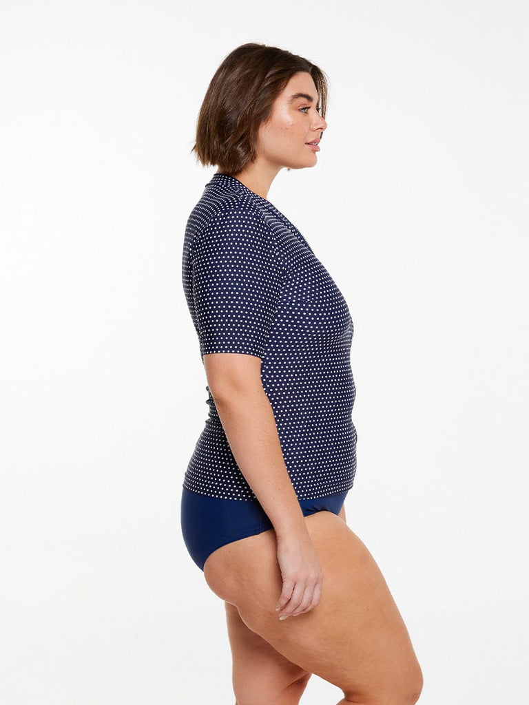model showing side of navy polka dot rash vest