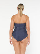 model showing back of navy polka dot strapless one piece
