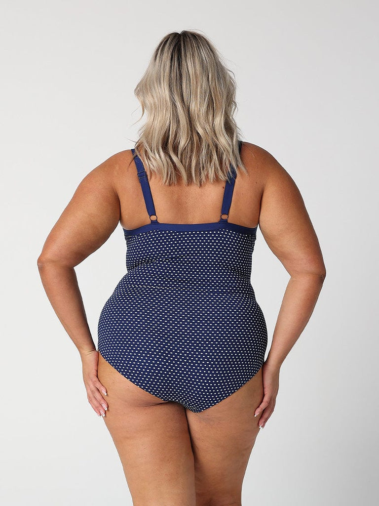 model showing back of navy polka dot one piece