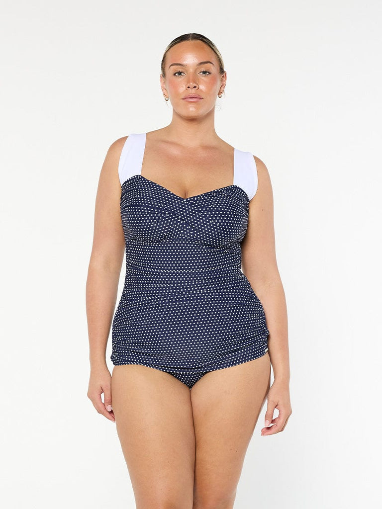 model wearing navy and white dots retro inspired one piece