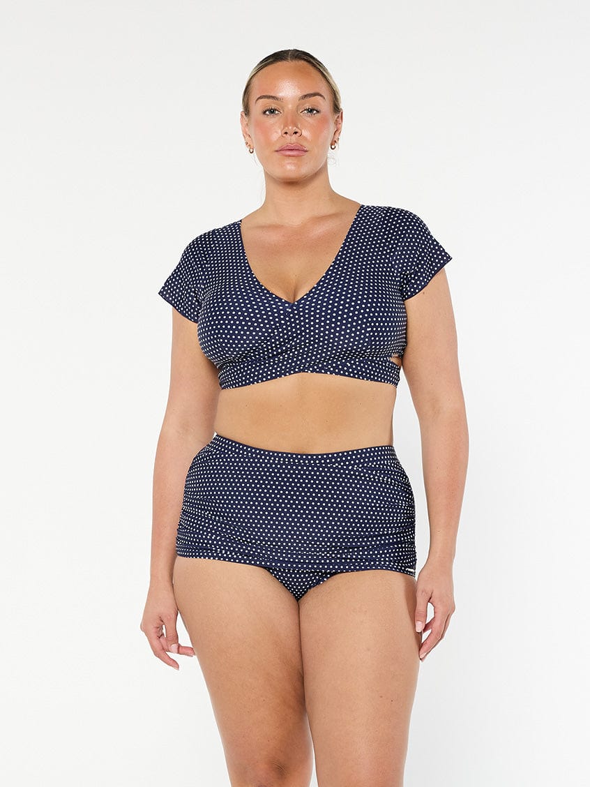 model wearing navy and white dots wrap crop top