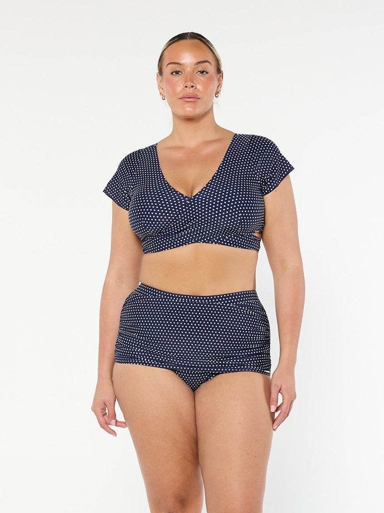 model wearing navy and white dots wrap crop top