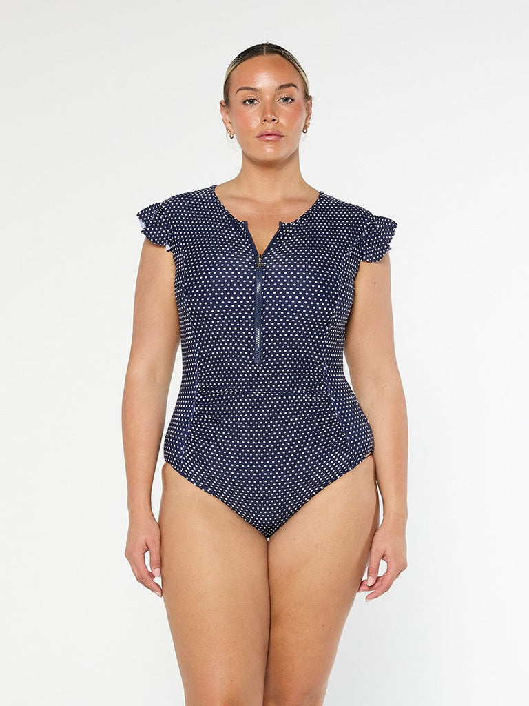 model wearing navy and white dots frill sleeve one piece