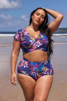 model wearing navy floral high waisted swim pants with matching top on beach