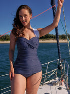 model wearing navy polka dot skirted swimsuit