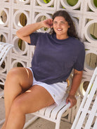 model sitting in navy terry towelling top