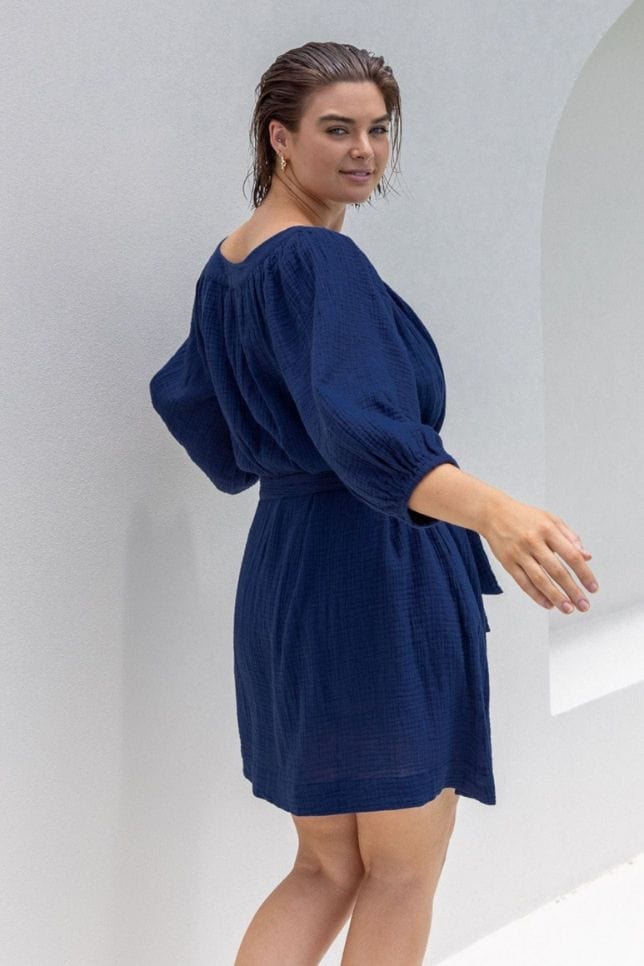 model wearing navy blue crepe dress with puffed sleeve and removable tie belt