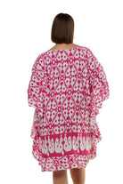 Brunette model wearing knee length pink and white block coloured beach cover u[