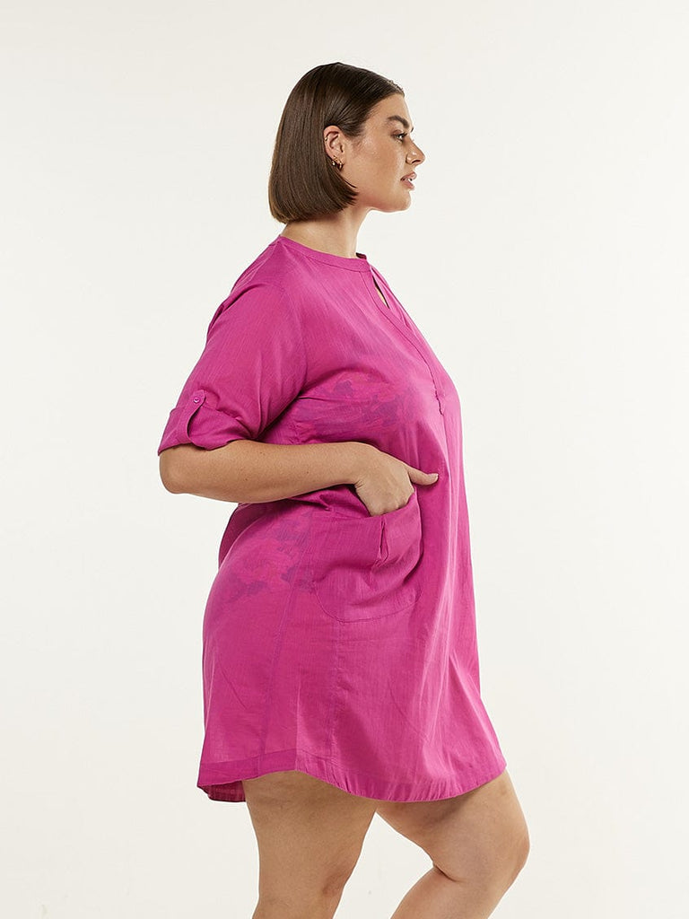 Model wearing pink beach dress with button up sleeves

