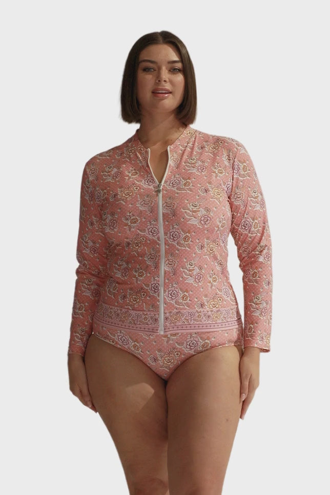 Brunette model wears blush floral long sleeve rash vest
