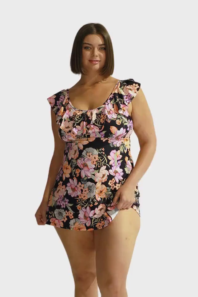 Brunette model wears black and orange floral swim dress