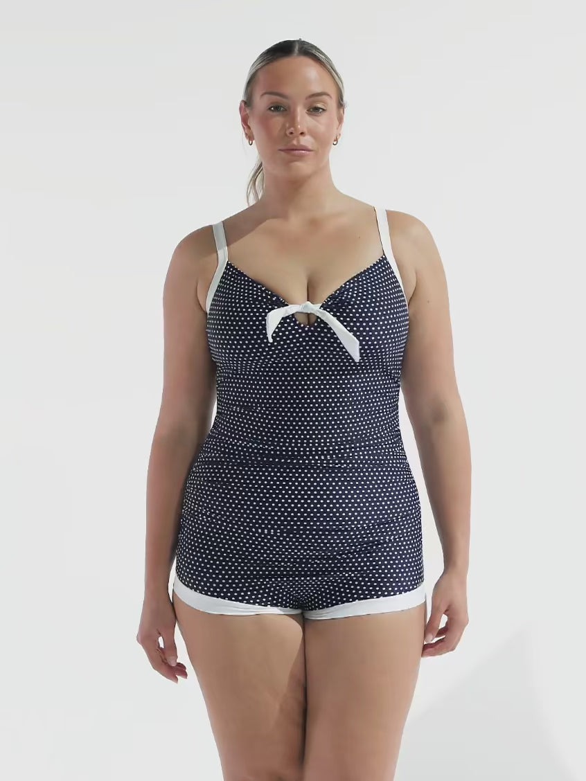 model wearing navy and white dots boyleg one piece with bow