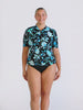 Blonde model in studio wearing a floral blue and black short sleeve rash vest