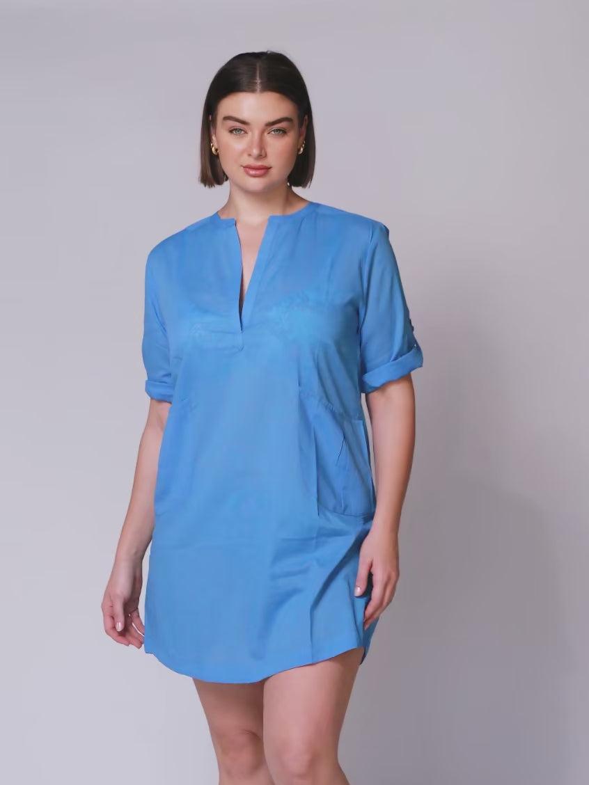 video of model wearing plus size over shirt. The provence blue shirt has roll up sleeves, v neck and pockets