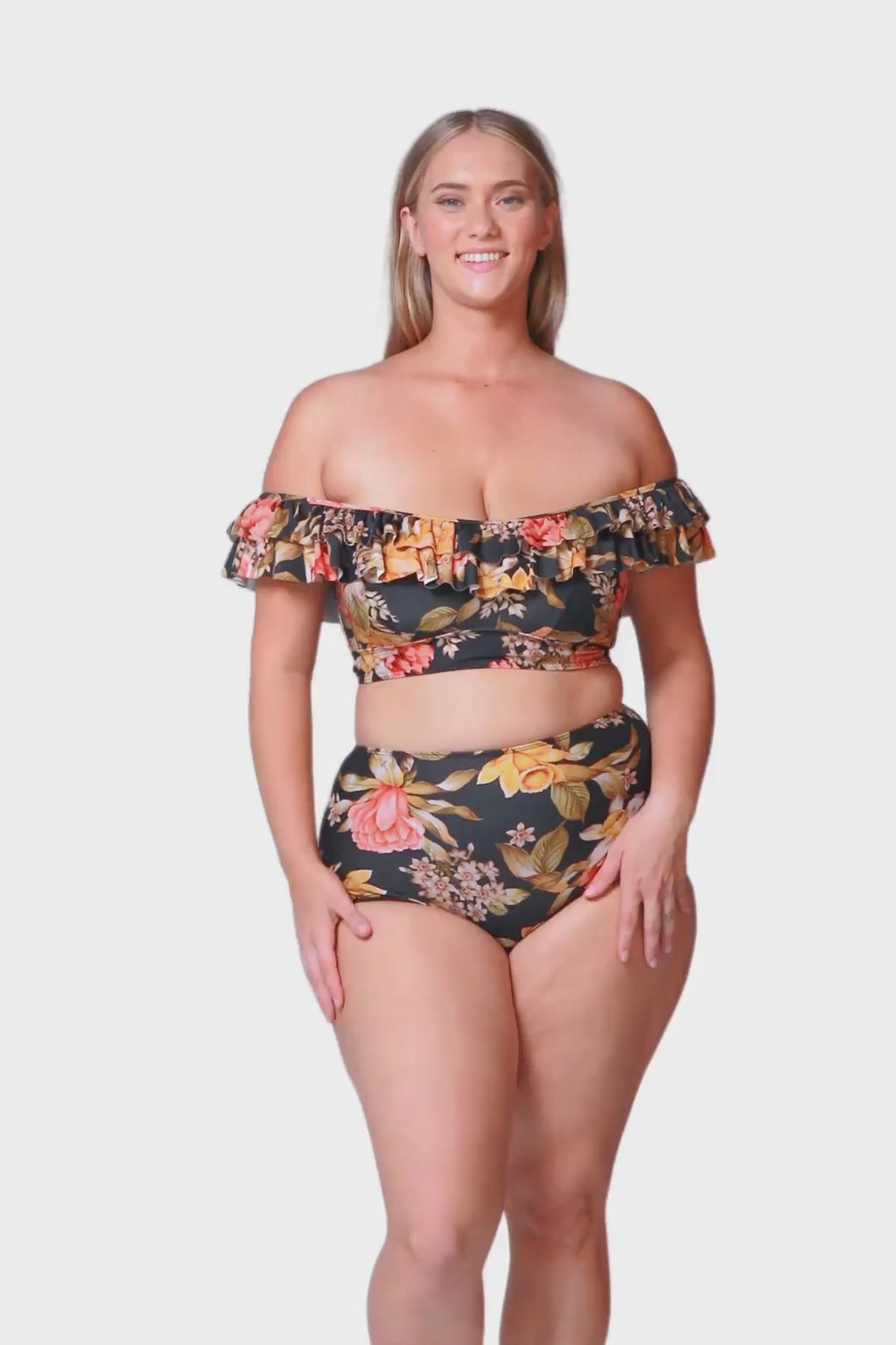 Model wearing mature ladies high waisted swim bottoms in floral print with black base and orange, red and yellow tones