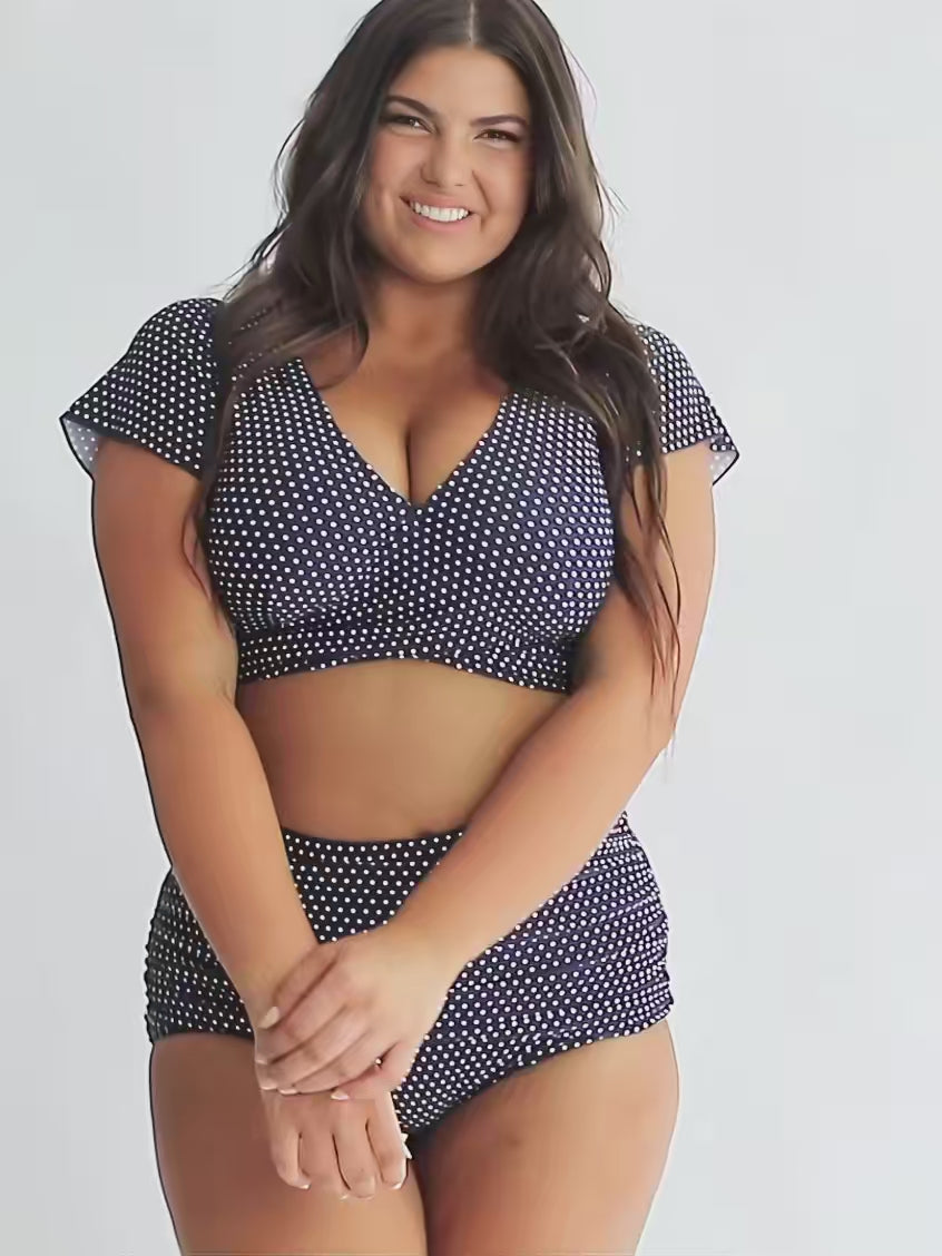 model wearing navy and white dots wrap crop top and matching bottoms