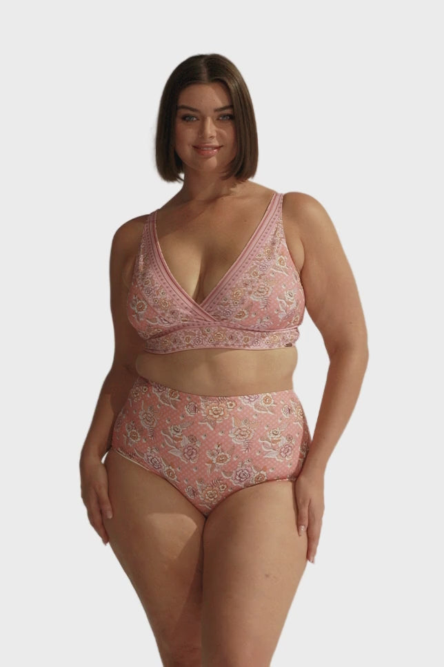 Brunette model wears pink floral high waisted bikini bottom