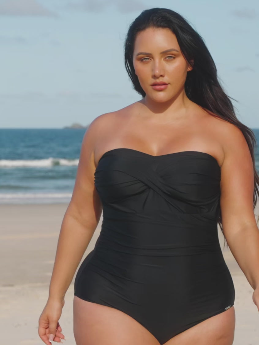model wearing black strapless swimsuit