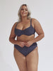 model wearing navy and white dots high rise bikini bottoms with matching underwire top