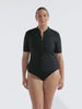 model wearing black short sleeve zip front rash vest