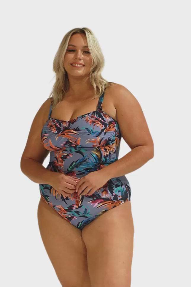 Model wearing blue-grey tropical print swimsuit