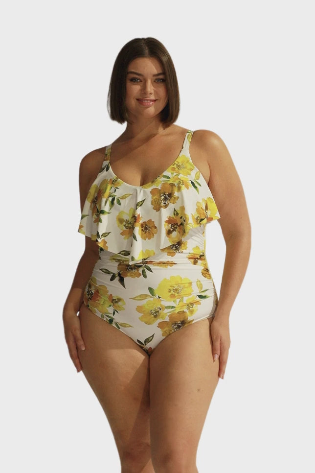 Brunette model wearing white and yellow floral frill one piece