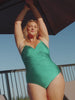 model wearing metallic emerald criss cross one piece